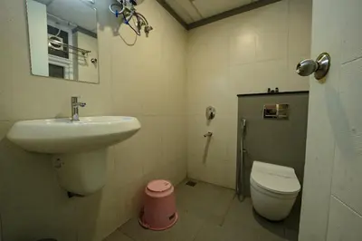 a bathroom with a sink and a toilet at Mirage Luxuria Inn in Vythiri
