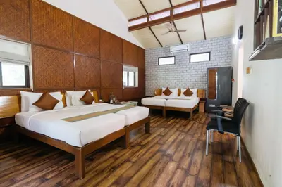 a bedroom with a bed and a couch and a chair at Discovery Village Kabini in Antarasante