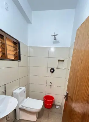 a bathroom with a white toilet and a sink at Hotel Riviera in Mananthavady
