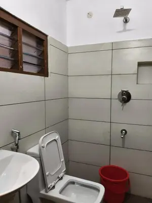 a bathroom with a toilet and a sink at Hotel Riviera in Mananthavady