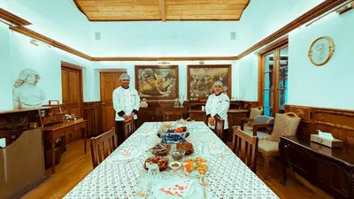 two chefs standing in a dining room with a table at Milntown Bungalow 200 years old Colonial Stay in Coonoor in Coonoor