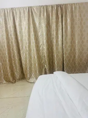 a bedroom with a bed and a curtain at AZURE stay happy in Pudunagaram