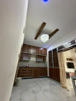 a kitchen with wooden cabinets and a ceiling at Forever Cottage by sait's hospitality in Ooty