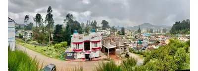 a town with a building in the middle of a city at Forever Cottage by sait's hospitality in Ooty
