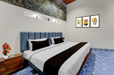 a bedroom with a large bed with a blue headboard at Palette Mithalai Farm by CheckIn | Garden | Pvt Pool | Coimbatore in Coimbatore