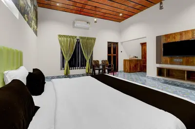 a bedroom with a large bed and a television at Palette Mithalai Farm by CheckIn | Garden | Pvt Pool | Coimbatore in Coimbatore