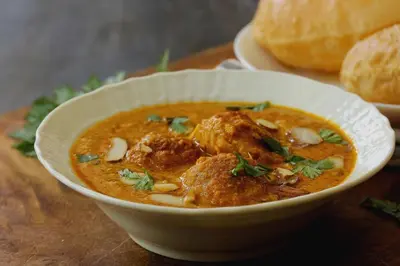 a bowl of soup on a table with a plate of bread at Palette Mithalai Farm by CheckIn | Garden | Pvt Pool | Coimbatore in Coimbatore