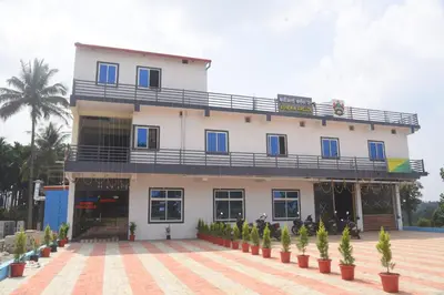 a large white building with potted plants in front of it at SOWMYA RESIDENCy in Piriyāpatna