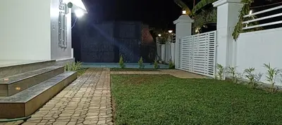 a garden with a bench and a fence at night at Heaven Cloud Stay Hub Attappadi in Attappādi
