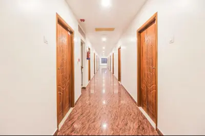 an empty corridor with wooden doors in a building at Sakthi Grand in Erode