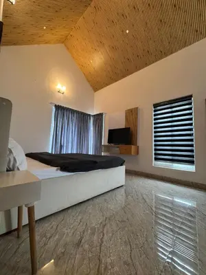 a bedroom with a large bed and a window at Black Dot Stays - Mehand Veera Residency in Kodaikānāl