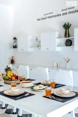 a white table with plates of food on it at StayVista at Mudra Tattva - Pvt Pool,Lawn,Jacuzzi 2BR Luxury Rooms in Suntikoppa