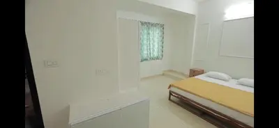a white room with a bed and a window at AZURE stay happy in Pudunagaram