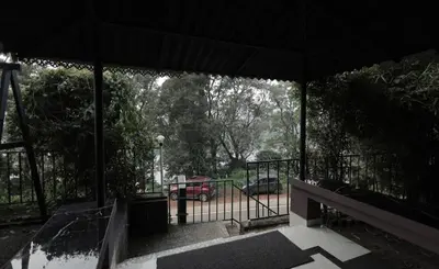 a pavilion with a bench and a parking lot at Chillwind Service villa in Padinjarathara