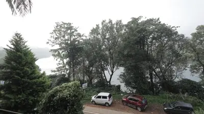 two cars parked in a parking lot with trees at Chillwind Service villa in Padinjarathara