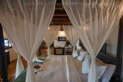 a bedroom with a large bed with curtains at SVS Arena in Kodali