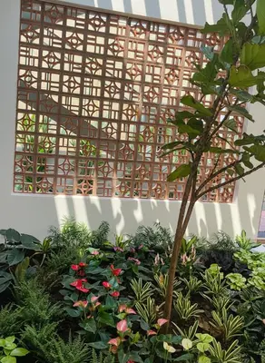 a garden with flowers and a bamboo structure at Nesara Home Stay Mysuru in Mysore