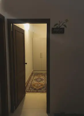 an open door leading to a hallway with a rug at Nesara Home Stay Mysuru in Mysore