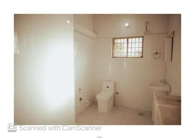 a bathroom with a toilet and a window at Coorg River Song Homestay in Kushālnagar