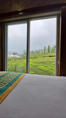 a bedroom with a bed with a view of a field at Meadows mist ooty in Ooty