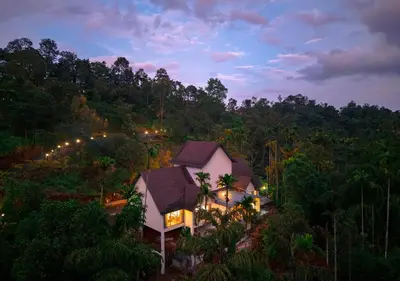 an aerial view of a house in the middle of a forest at Achutham Cottages Wayanad by VOYE HOMES in Padinjarathara