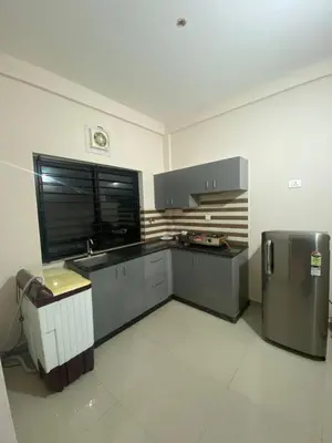 a kitchen with a sink and a refrigerator at Neurogreen Apartments in Kottakkal
