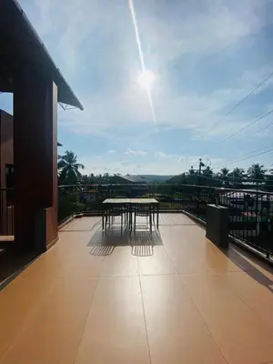 a patio with a table on top of a balcony at Neurogreen Apartments in Kottakkal