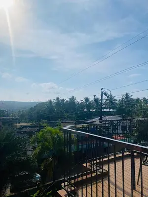 a balcony with a view of a city with palm trees at Neurogreen Apartments in Kottakkal
