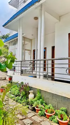 a building with potted plants in front of it at The Haze Land in Ooty