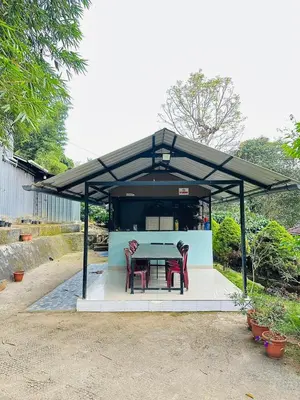a picnic shelter with a table and two chairs at Nefs Dreams Villa in Vaduvanchal