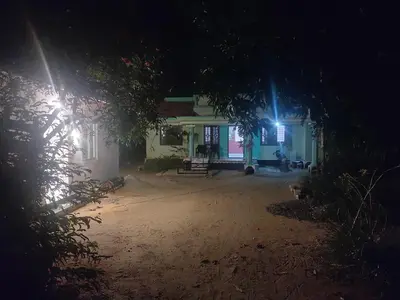 a house at night with two lights on it at Katadi beach coral cottage in Thanniyam