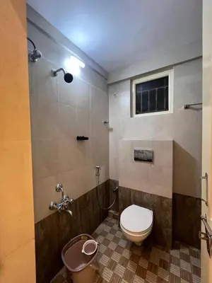a bathroom with a toilet and a shower with a window at Kvm RIVER VIEW - 2bhk in Palakkad