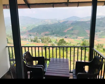 a table and chairs on a balcony with a view at Bison valley resort Anikorai in Ooty