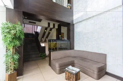 a living room with a couch and a staircase at FabHotel Sholas Residency I - Nr Government Rose Garden in Ooty
