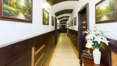 a hallway in a house with paintings on the walls at FabHotel Sholas Residency I - Nr Government Rose Garden in Ooty