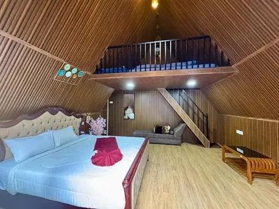 a bedroom with a large bed with a wooden ceiling at Wings Cottage in Ooty