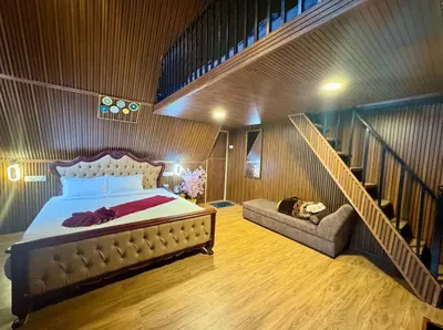 a bedroom with a large bed and a staircase at Wings Cottage in Ooty