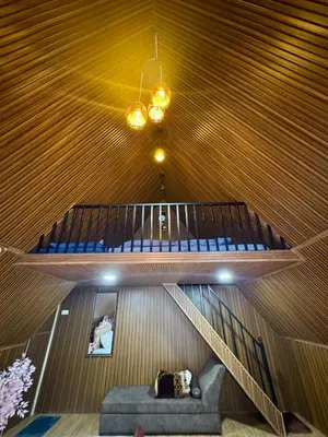 a staircase in a room with a couch and a ceiling at Wings Cottage in Ooty