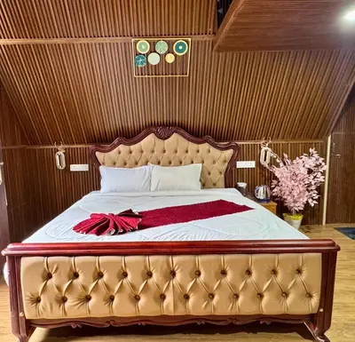 a bedroom with a large bed with a red bow on it at Wings Cottage in Ooty