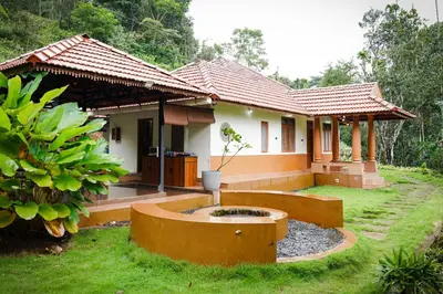 a house with a fountain in front of it at Chestnut Villa in Wayanad