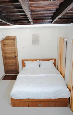 a bed with a wooden frame in a room at Chestnut Villa in Wayanad