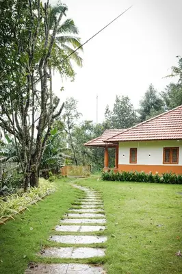 a house with a pathway leading to a yard at Chestnut Villa in Wayanad