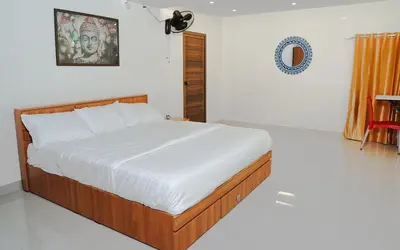 a bed in a white room with at Chestnut Villa in Wayanad
