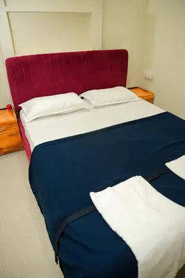 a large bed with a red headboard in a room at Dua farms in Sultan Bathery