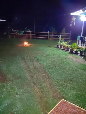 a backyard at night with a fire in the grass at Airin's Villa in Agali