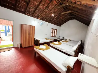 a room with three beds and a window at Rafters Retreat Coorg - The Riverside Homestay in Srimangala