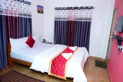 a bedroom with a white bed with red pillows at Coorg Holiday Homes in Madikeri