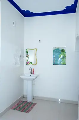 a white bathroom with a sink and a mirror at Coorg Holiday Homes in Madikeri