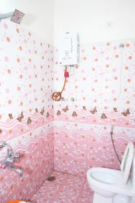 a pink bathroom with a toilet and a sink at Coorg Holiday Homes in Madikeri