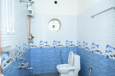 a blue bathroom with a toilet and a sink at Coorg Holiday Homes in Madikeri